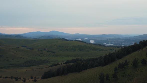 Aerial view from a drone on valley and mountains under blue sky with clouds alt