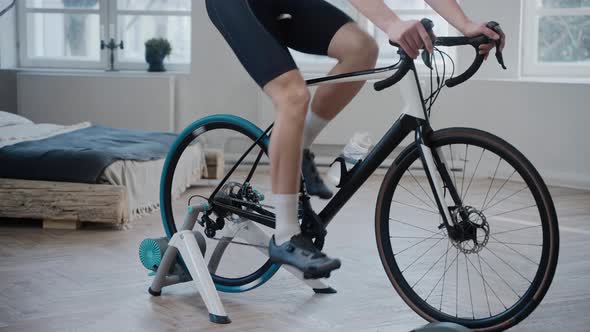 Shot of the Legs of a Cyclist Training on an Exercise Bike at Home