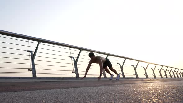 Athletic Guy with Muscular Torso Do Pushups Outdoor Morning Training