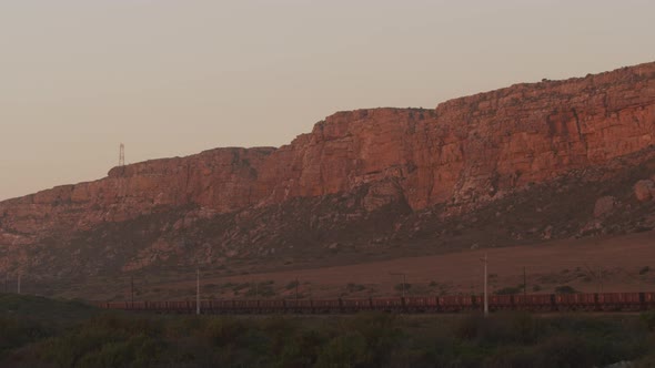 Steady Shot of Transport Cargo Trains Against Mountainous Rocks alt