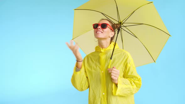 A Smiling Woman with Red Glasses and Yellow Umbrella Dreaming About Rain