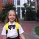 Happy Little Caucasian Blonde Girl Seven Years Old in Uniform with Yellow Backpack Going Back to - VideoHive Item for Sale