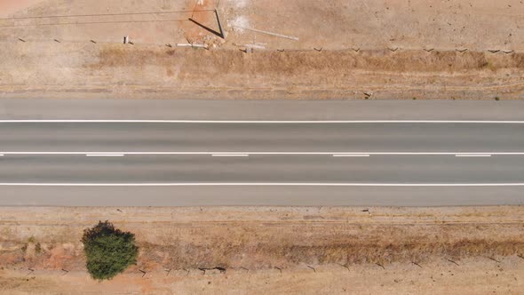 Top Down View Flying Over Desert Road with Trucks