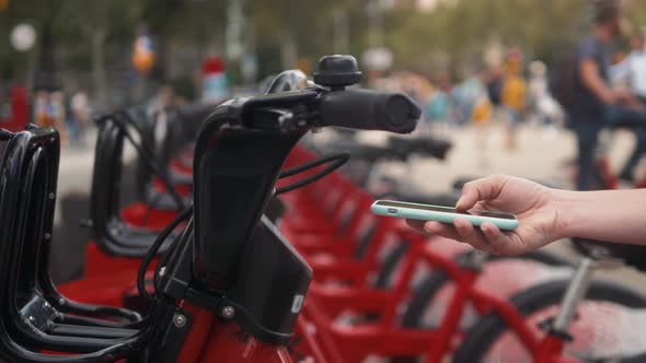 Woman Take Electric Kick Scooter or Bike Bicycle in Sharing Parking Lot Tourist Phone Application alt