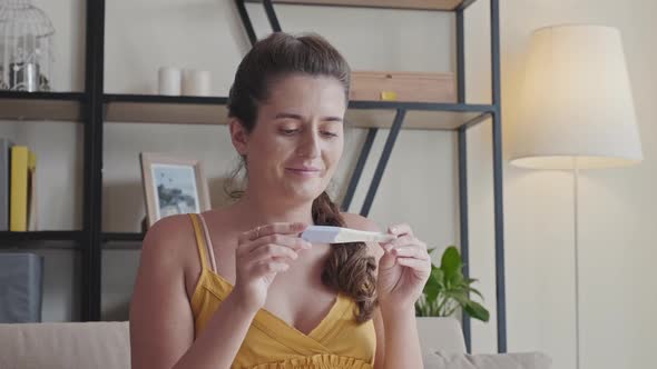 Woman Looking at Pregnancy Test at Home alt