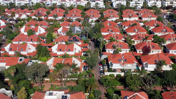 Classic Suburban houses with red rooftops and green trees. alt