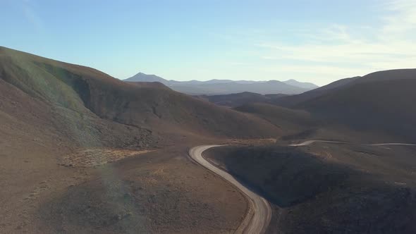 Aerial View of a Road Leading Through Vast Area of Volcanic Land and Mountains