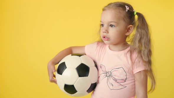 Authentic Cute Smiling Preschool Little Girl with Classic Black and White Soccer Ball Look at Camera