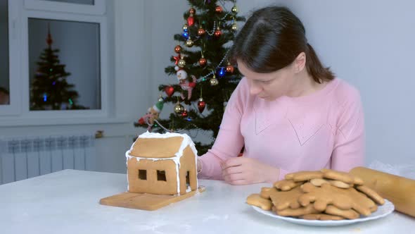 Portrait of Woman Making Gingerbread House Glues Details Sugar Sweet Icing