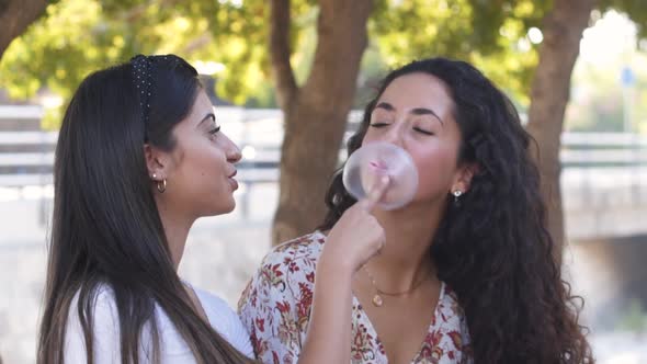 Multiethnic Hipster Friends Having Fun Blowing and Popping Gum Bubble