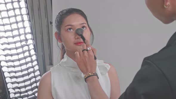 Backstage Of The Photo Shoot: Make-Up Artist Applies Makeup On Beautiful Asian Model alt