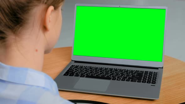 Woman Looking at Laptop with Empty Green Display