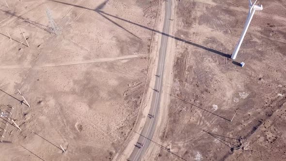 Cyclists Ride Along Road with a View of Windmills. alt