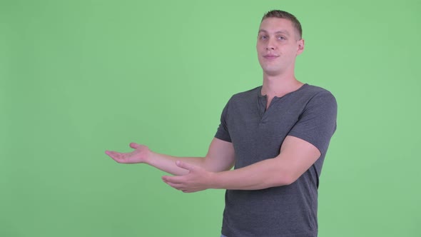 Portrait of Stressed Young Man Showing Something To the Back alt