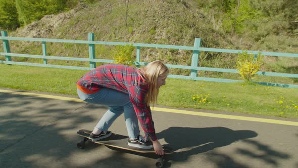 Active Woman Skater Practicing Skateboarding Skills in Public Park alt