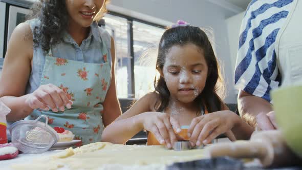 Girl learning to cut cookies with her mother and granny 4K 4k alt