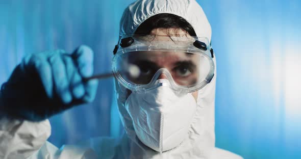 Doctor Makes Swab in Covid Suit alt