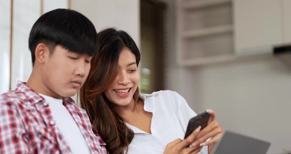 Young man working on laptop and disinterested girlfriend alt
