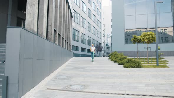 Man Courier on Scooter Delivering Food in Town Streets with a Hot Food Delivery alt