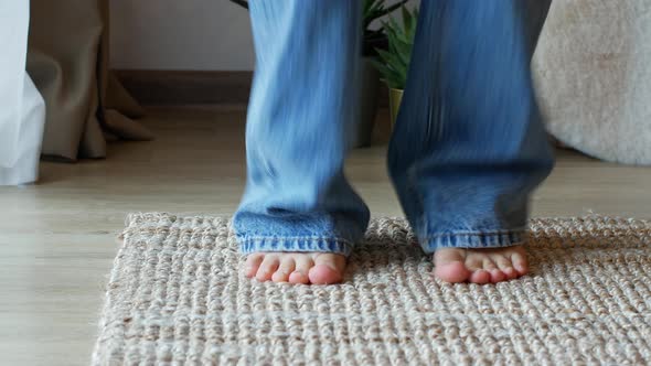 The woman bounces standing on the carpet.