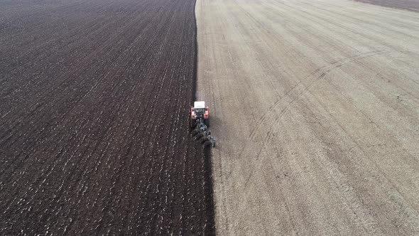 Agricultural Red Small Tractor in the Field Plowing alt
