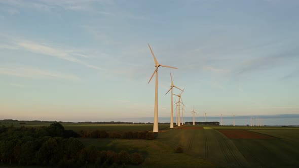 Horizontal Panning From a Drone View of a Massive Wind Farm Among Green Fields alt