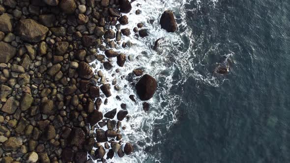 Moving Over Ocean Waves Crashing Coastline with Huge Boulders