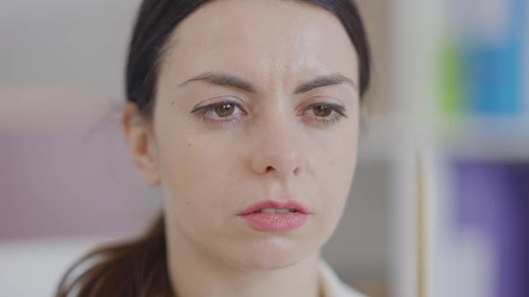 Closeup Face of Young Concentrated Woman Looking at Pencil and Away alt