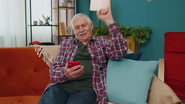 Senior Grandfather Use Mobile Cell Phone Online Shopping Found Out Great Big Win Celebrate at Home alt