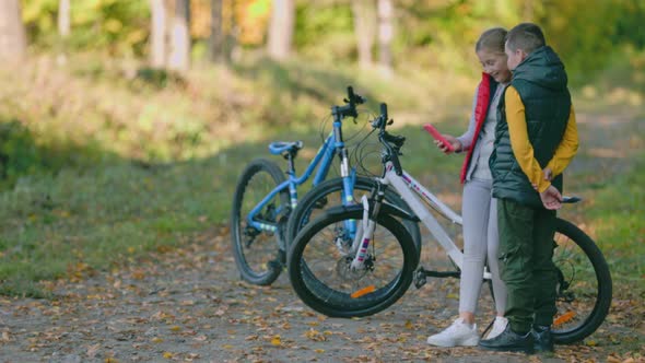 Children Look at the Phone While in Nature alt