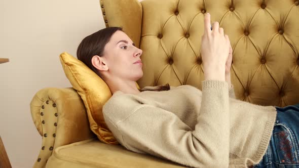 Close Up View Of A Girl On The Couch With Smartphone