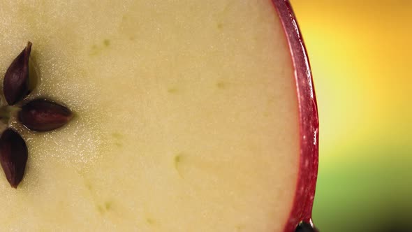 Drop of Water Flows Down the Surface of a Ripe Juicy Red Apple Slice alt