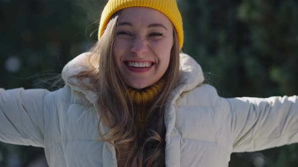 Closeup of Happy Joyful Caucasian Woman Standing in Sunlight Outdoors Tossing Snow Smiling Looking alt