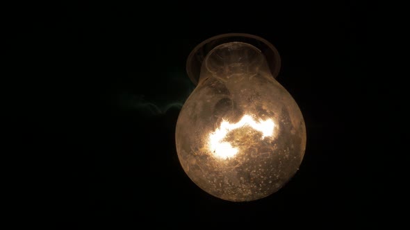 Swinging dusty light bulb in the dark 4K 2160p UHD video - Light bulb swing horror scene 4K 3840X216 alt