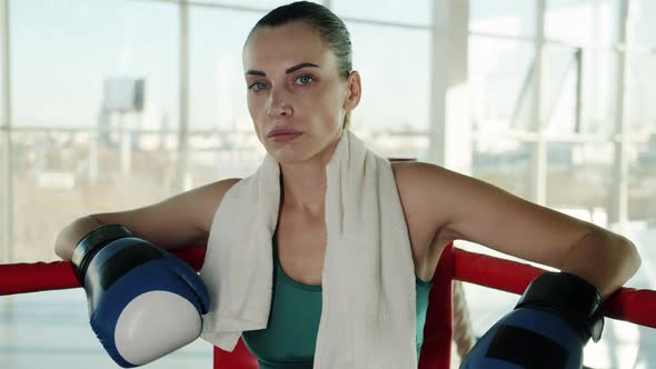 Slow Motion Portrait of Successful Boxer Resting in Ring Corner Wearing Gloves alt