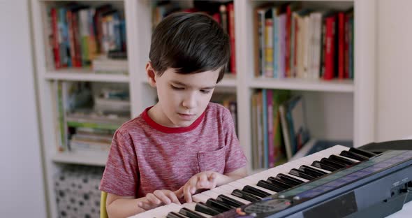 Boy Practising Playing on Piano Electronic Keyboard