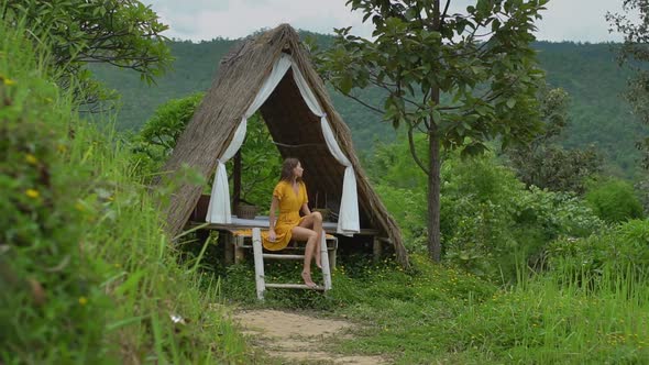 Woman Seats on the Stars of Tropical Bungalow alt