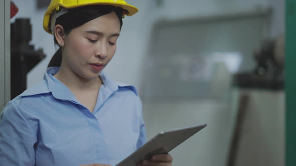Asian female engineer or factory worker using laptop checking on an electric system alt