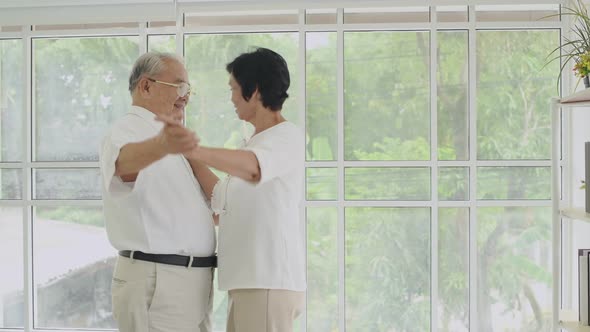 Family concept. Senior couple dancing inside the house. 4k Resolution. alt