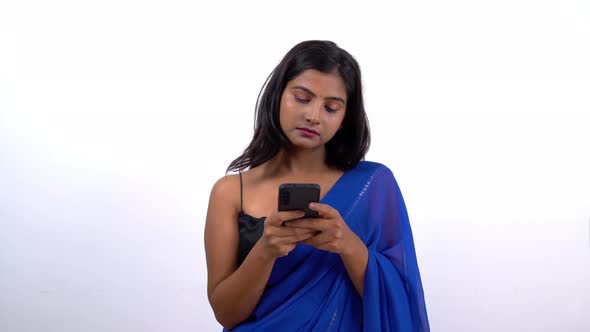 Indian woman in saree chatting with someone on a messaging app alt