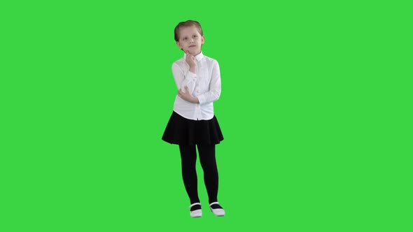 A Curious Little Girl Stands and Thinks on a Green Screen, Chroma Key alt