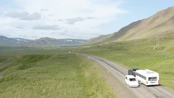 Campervan Being Towed On Rural Road By A Pickup Vehicle In Westfjords, Iceland. aerial following alt