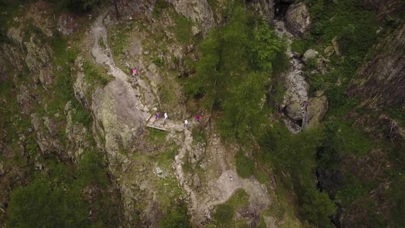 Drone shot of a natural path in the swiss alps, people are walking. aerial shot alt