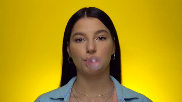 Woman Blowing Bubble Gum and Looking To Camera