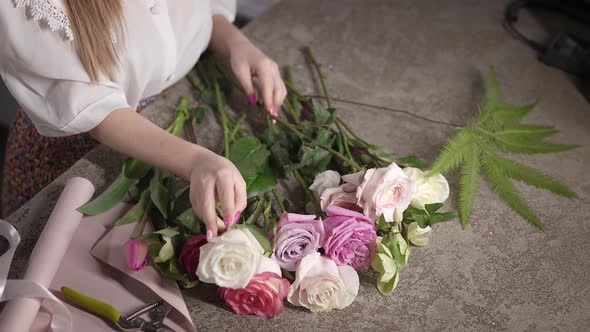 In the Frame Female Hands with a Good Manicure and Flowers for a Bouquet alt