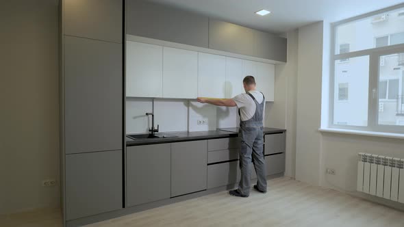 The Builder Checks the Dimensions and Quality of Installation of the Kitchen Furniture Structure alt