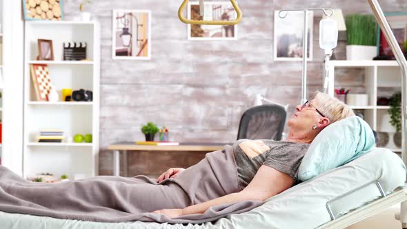 Old Lady Lying on Hospital Bed in Nursing Home alt