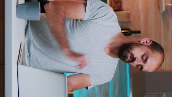 Vertical Video Man Taking a Break From Work and Streching His Neck alt