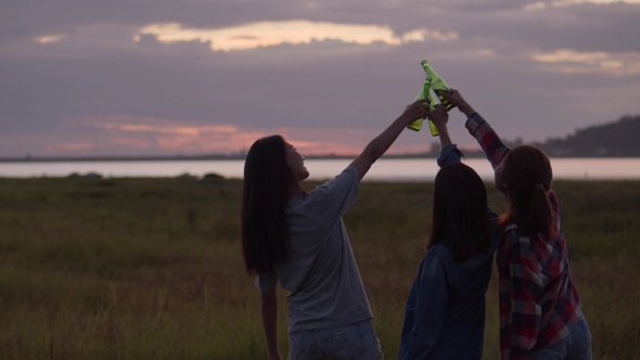 Group of young teen Asian women happy friends camping in nature having fun together drinking beer.