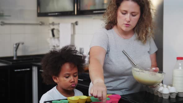 White Mother with Her Black Mixed Daughter Making Dough on the Kitchen alt